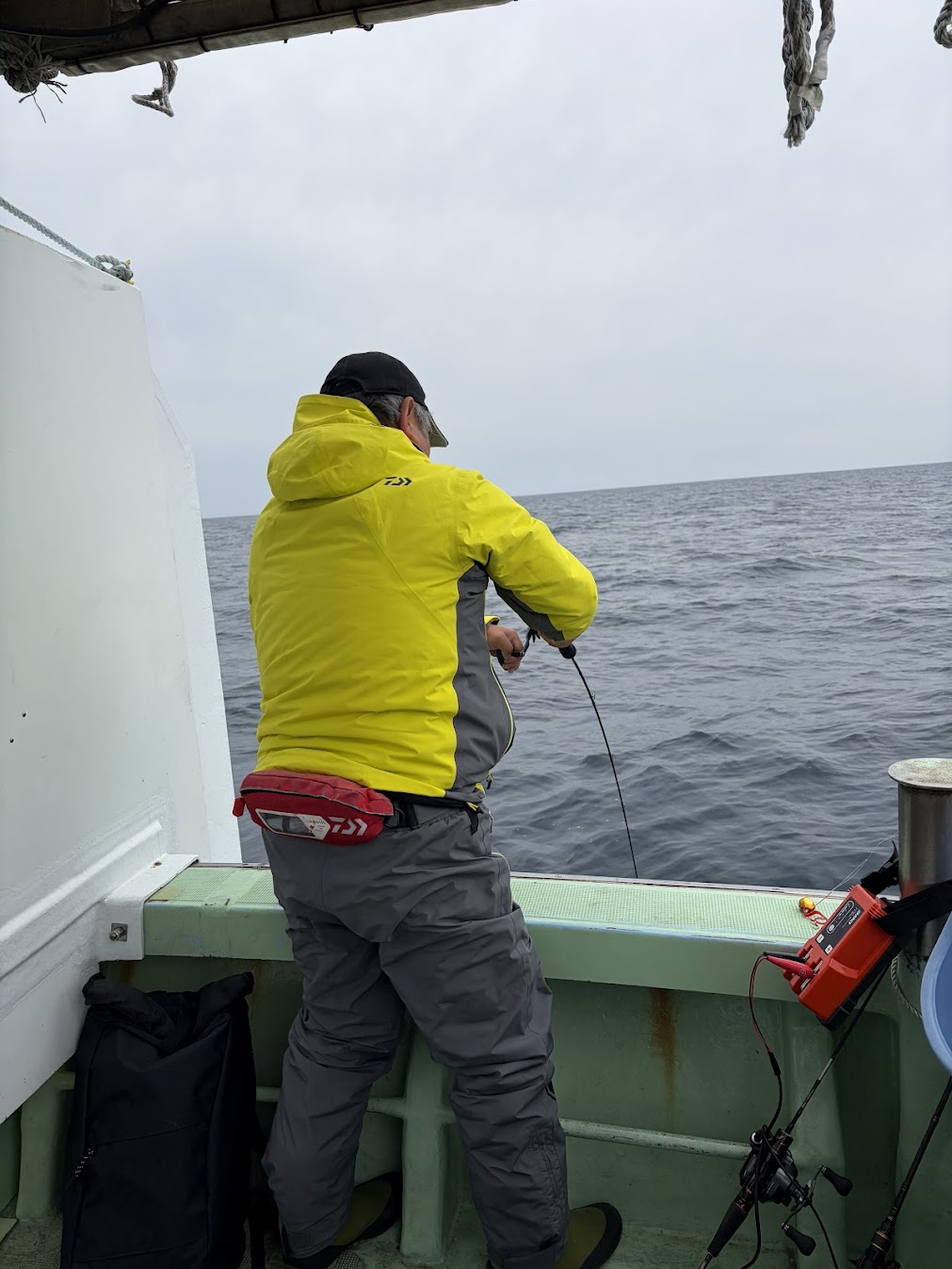 大型の魚を釣っている途中の釣り好きの人