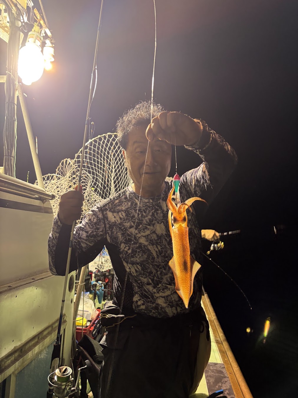 ケンサキイカを楽しんで釣る年配の男性